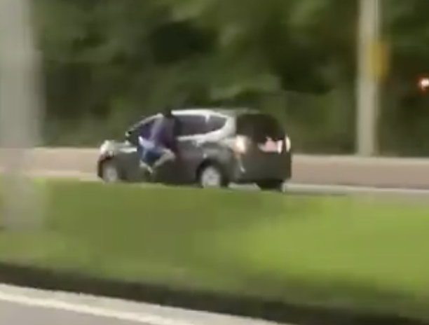 Insólito. Homem apoia-se em janela de carro em andamento depois de tentar roubar o condutor