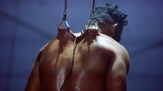 Cantor Miguel surge em palco com as costas perfuradas com ganchos e fica suspenso. Veja o vídeo