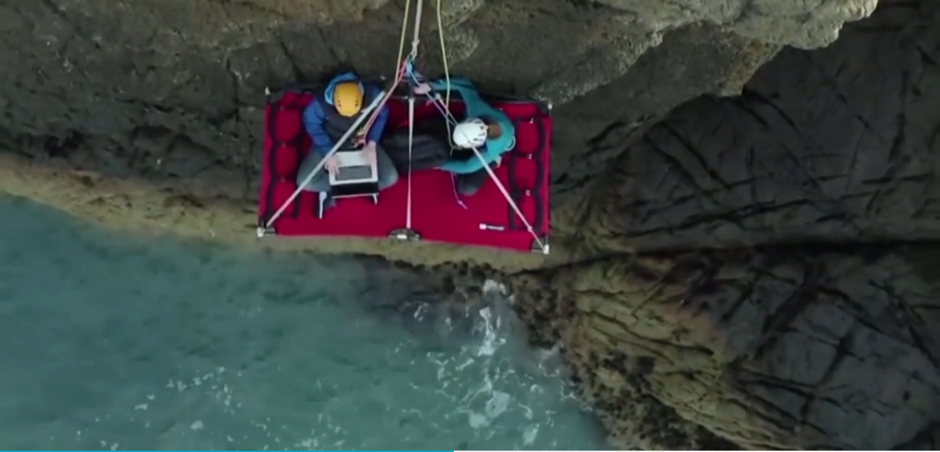 Trabalhar suspenso numa falésia? É possível — e este homem é a prova disso. Veja o vídeo