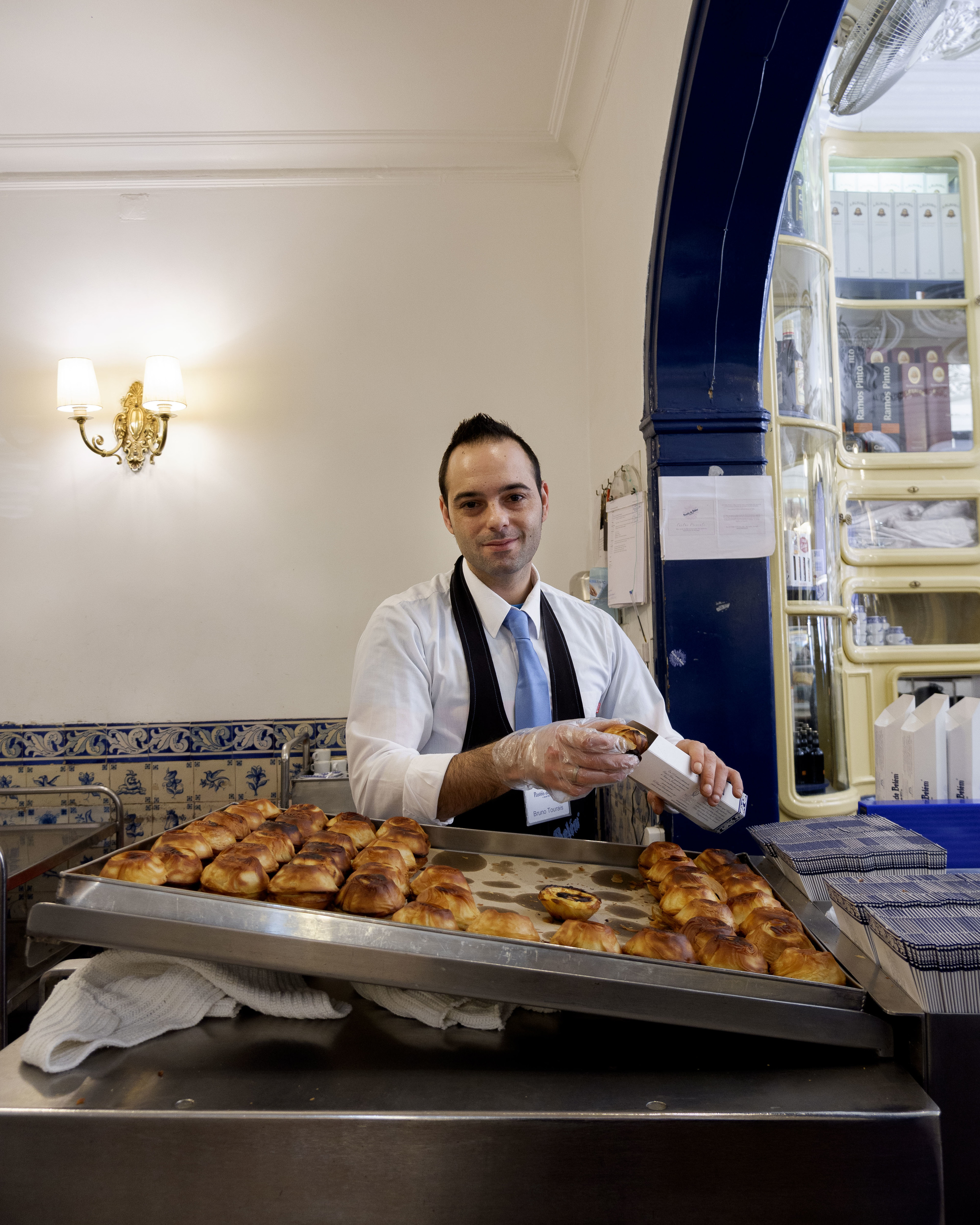 Com ou sem canela mas sempre quentes — são estes os anónimos que lhe preparam os Pastéis de Belém